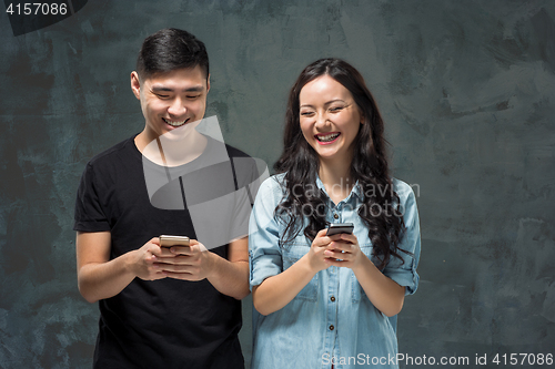 Image of Asian young couple using cellphone, closeup portrait.