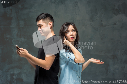 Image of Asian young couple using cellphone, closeup portrait.