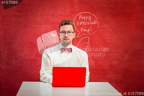 Image of Young funny man with laptop at St. Valentine\'s Day