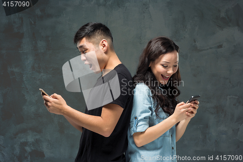 Image of Asian young couple using cellphone, closeup portrait.