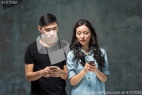 Image of Asian young couple using cellphone, closeup portrait.