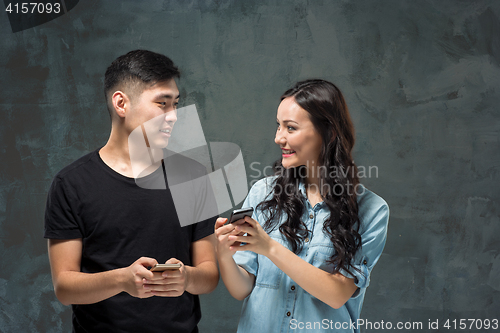 Image of Asian young couple using cellphone, closeup portrait.