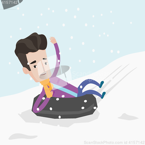 Image of Man sledding on snow rubber tube in the mountains.