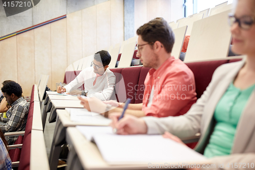 Image of group of students with notebooks in lecture hall