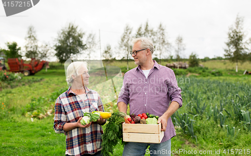 Image of senior couple with box of vegetables on farm