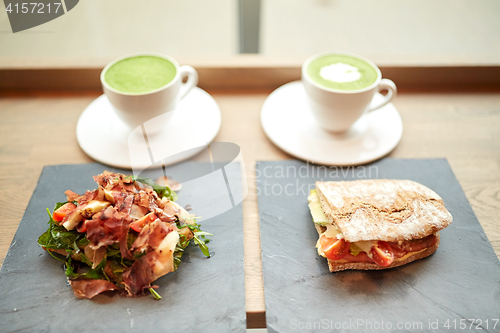 Image of salad, sandwich and matcha green tea at restaurant