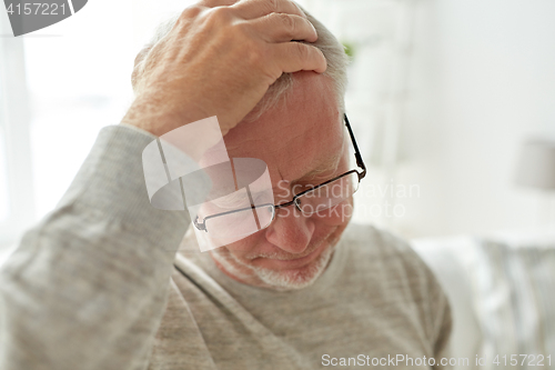 Image of senior man suffering from headache at home