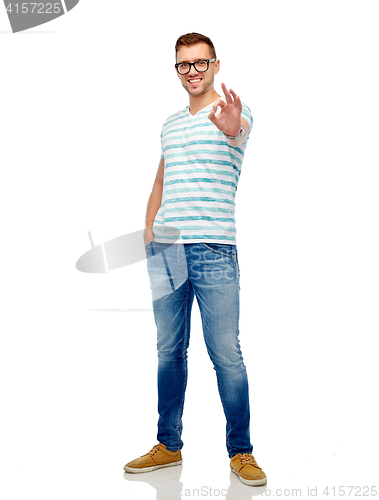 Image of young man in eyeglasses showing ok hand sign