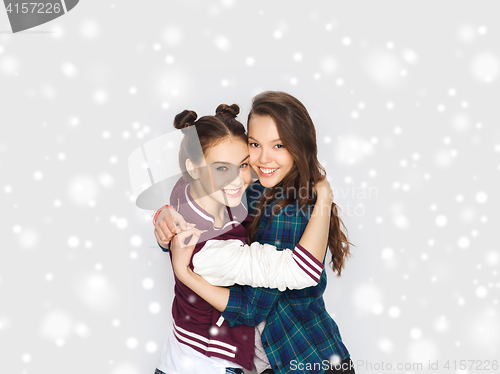 Image of happy smiling teenage girls hugging over snow