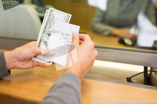 Image of customer with money and receipt at bank counter