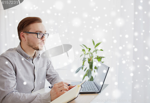 Image of creative man or businessman writing to notebook