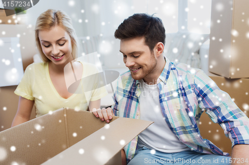 Image of smiling couple with big boxes moving to new home