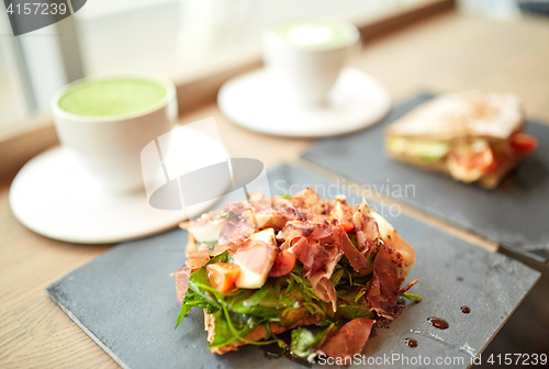 Image of prosciutto ham salad on stone plate at restaurant