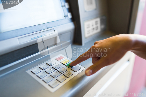 Image of close up of hand entering pin code at atm machine