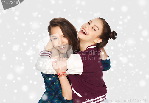 Image of happy smiling teenage girls hugging over snow