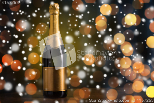 Image of bottle of champagne with golden label over snow