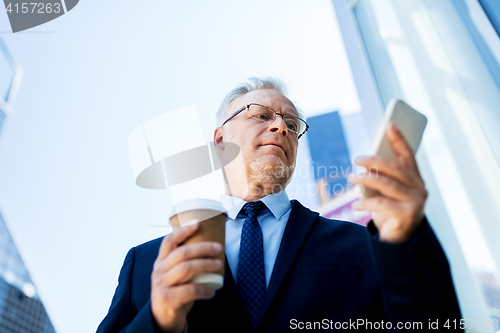 Image of businessman with smartphone and coffee in city