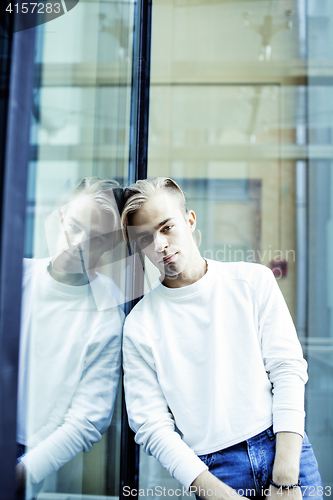 Image of young modern hipster guy at new building university blond fashion hairstyle having fun, lifestyle people concept