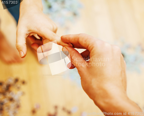 Image of little kid playing with puzzles on wooden floor together with pa