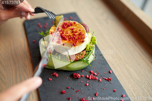 Image of woman eating goat cheese salad at restaurant