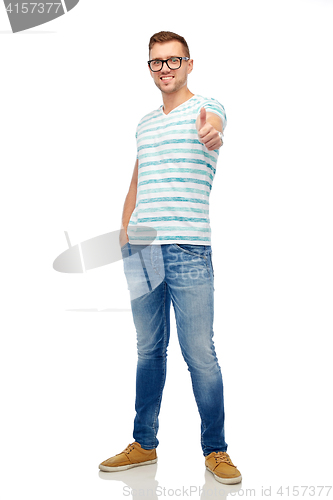 Image of young smiling man in eyeglasses showing thumbs up