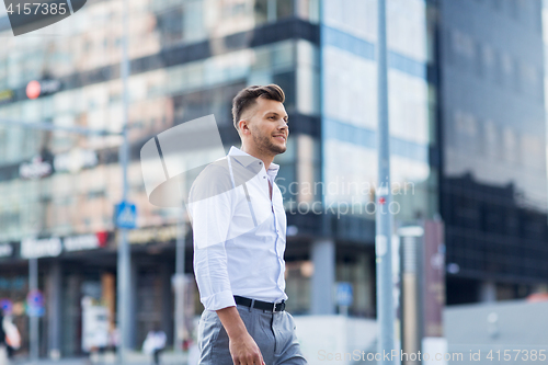 Image of young man walking along city street