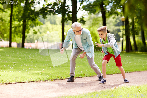 Image of grandfather and grandson racing at summer park