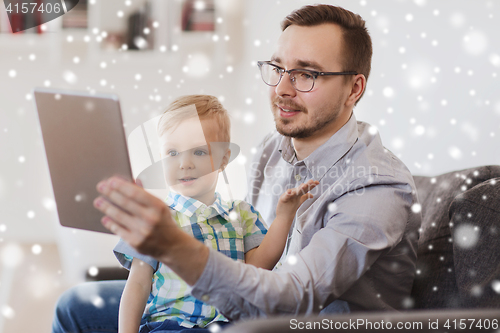 Image of father and son with tablet pc playing at home