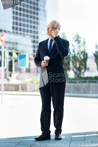 Image of senior businessman calling on smartphone in city