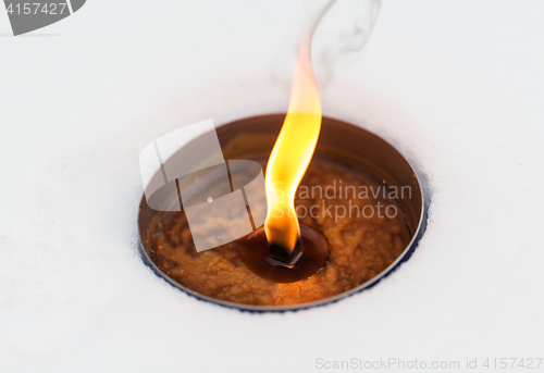 Image of christmas outdoor candle burning on snow in winter