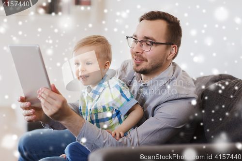 Image of father and son with tablet pc playing at home