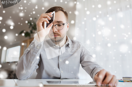 Image of businessman with smartphone at home office