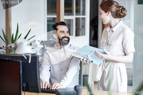 Image of business team with computer and files in office