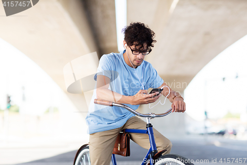 Image of man with smartphone and earphones on bicycle