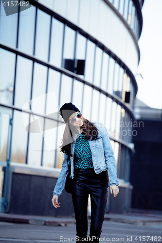 Image of young pretty girl near business building walking