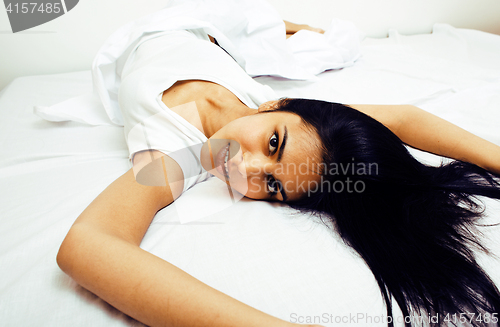 Image of young pretty tann woman in bed among white sheets having fun, tr