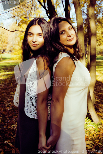 Image of mature real mother with daughter outside autumn fall in park