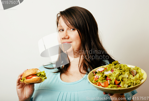 Image of fat white woman having choice between hamburger and salad close 