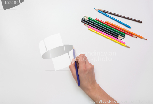 Image of Woman\'s hand draws a pencil on paper, close-up, top view