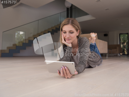 Image of young women used tablet computer on the floor