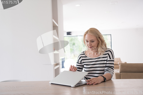 Image of Young woman with laptop at home