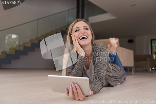 Image of young women used tablet computer on the floor
