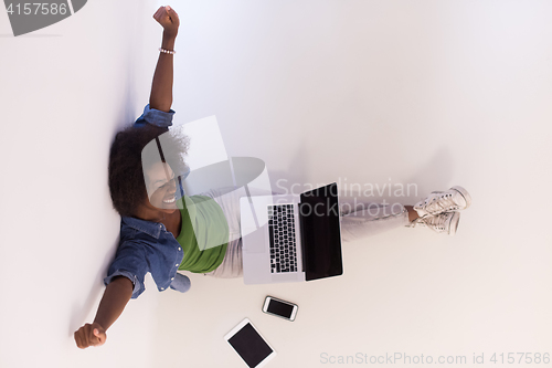 Image of african american woman sitting on floor with laptop top view