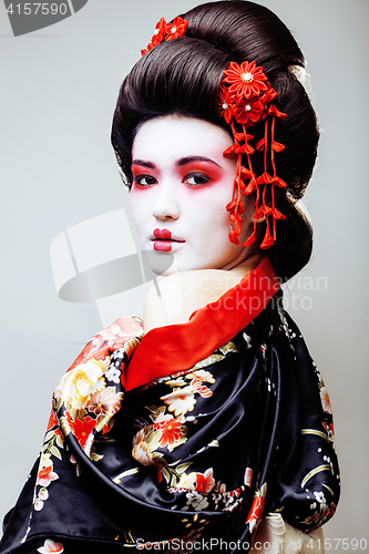 Image of young pretty geisha in black kimono among sakura, asian ethno