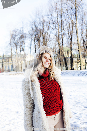 Image of young pretty teenage hipster girl outdoor in winter snow park having fun drinking coffee, warming up happy smiling, lifestyle people concept