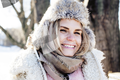 Image of young pretty teenage hipster girl outdoor in winter snow park having fun drinking coffee, warming up happy smiling, lifestyle people concept