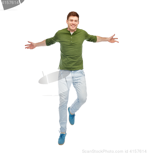 Image of smiling young man jumping in air