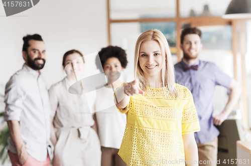 Image of woman pointing to you over creative office team