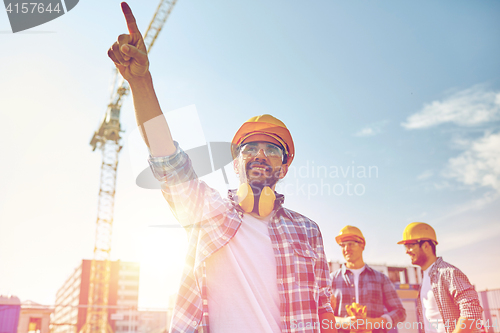 Image of builders pointing finger aside on construction