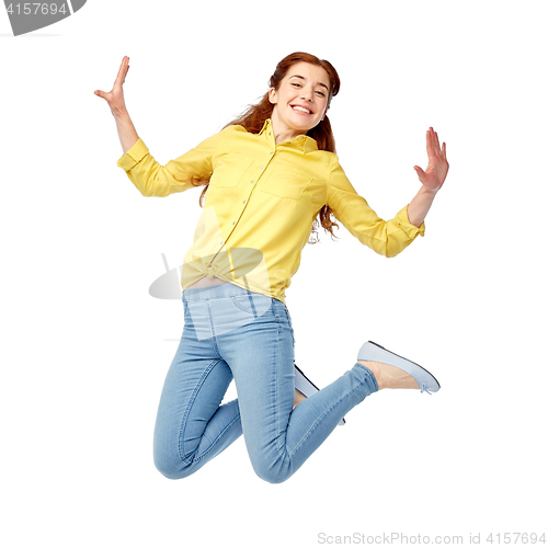 Image of smiling young woman jumping in air